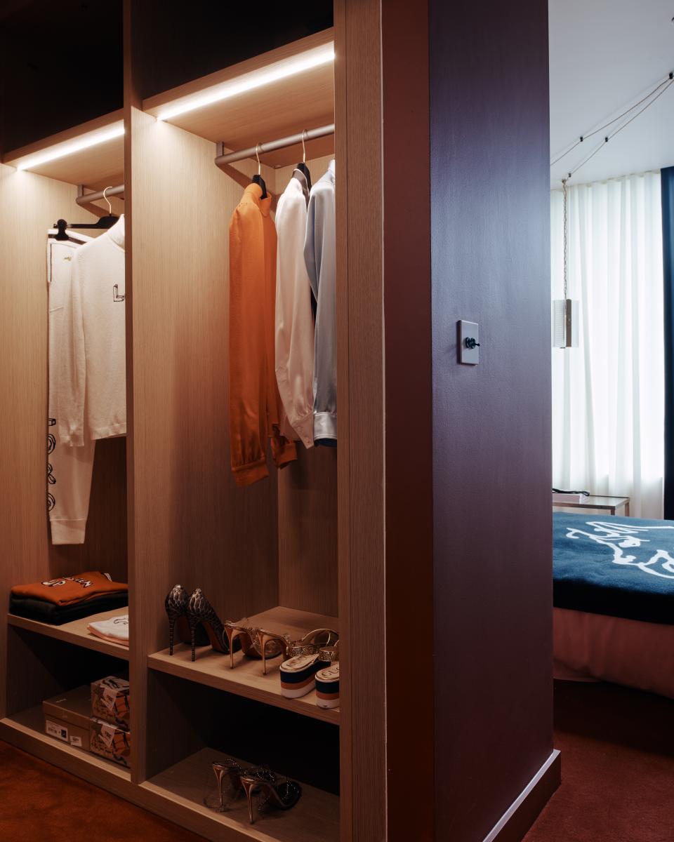Elegant wardrobe with designer clothing and stylish shoes, showcasing Bella Freud and Maria Speake’s sophisticated interior design at Helios 710.