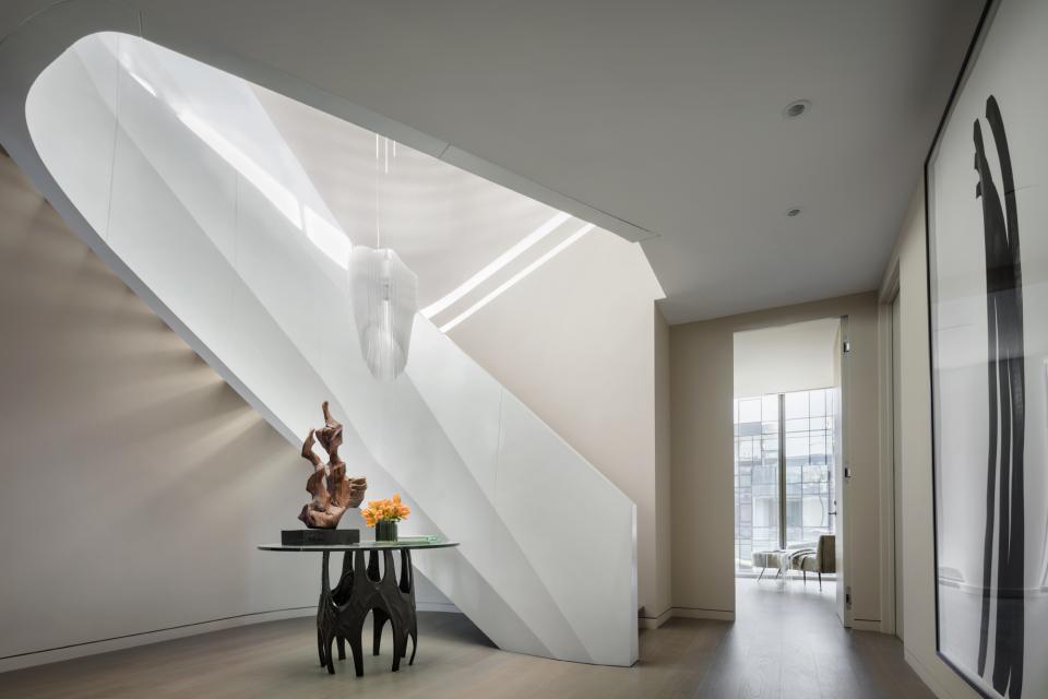 Stylish interior of Zaha Hadid's luxury penthouse, featuring a sculptural staircase and artistic decor elements.
