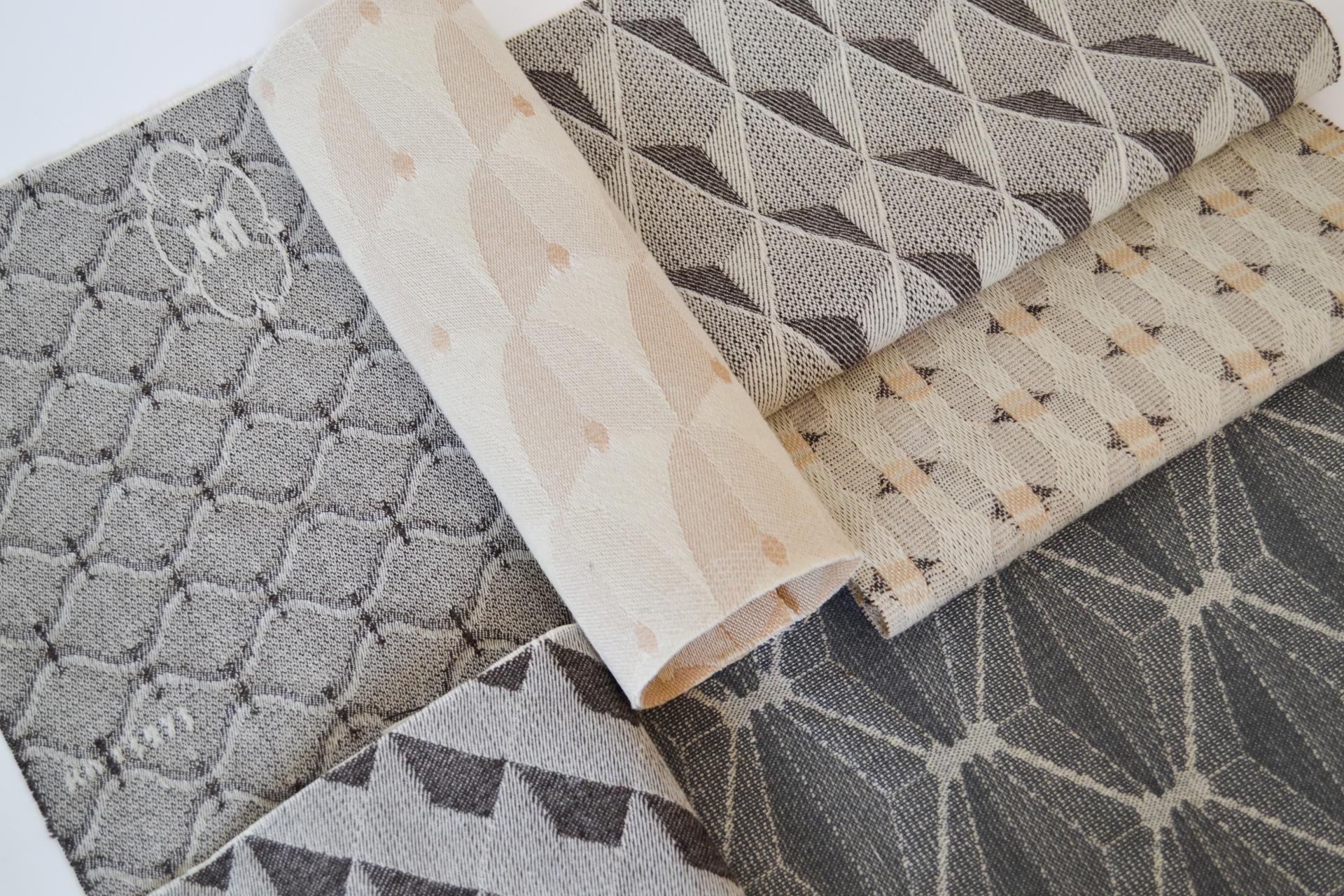 Textiles featuring intricate geometric patterns displayed at the Surface Design Show, highlighting innovative surface design talent.