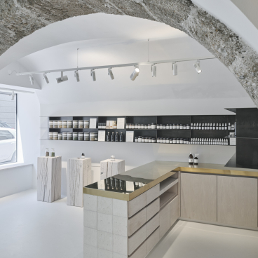 Saint Charles' Salzburg store features natural cosmetics displayed on stylish wooden and stone furnishings in a modern interior.