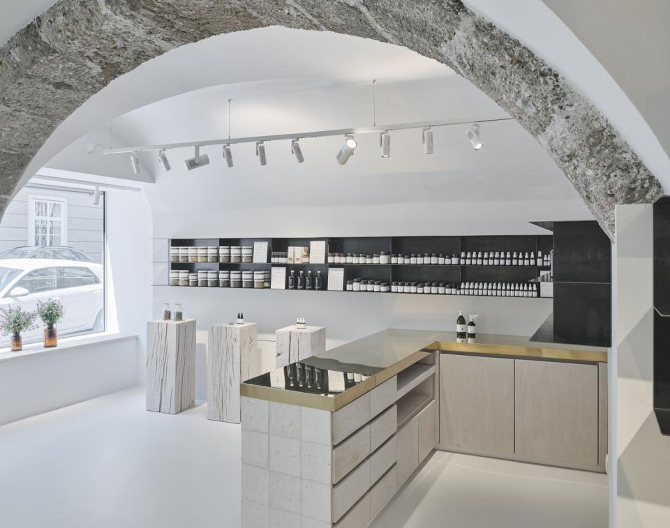 Saint Charles' Salzburg store features natural cosmetics displayed on stylish wooden and stone furnishings in a modern interior.