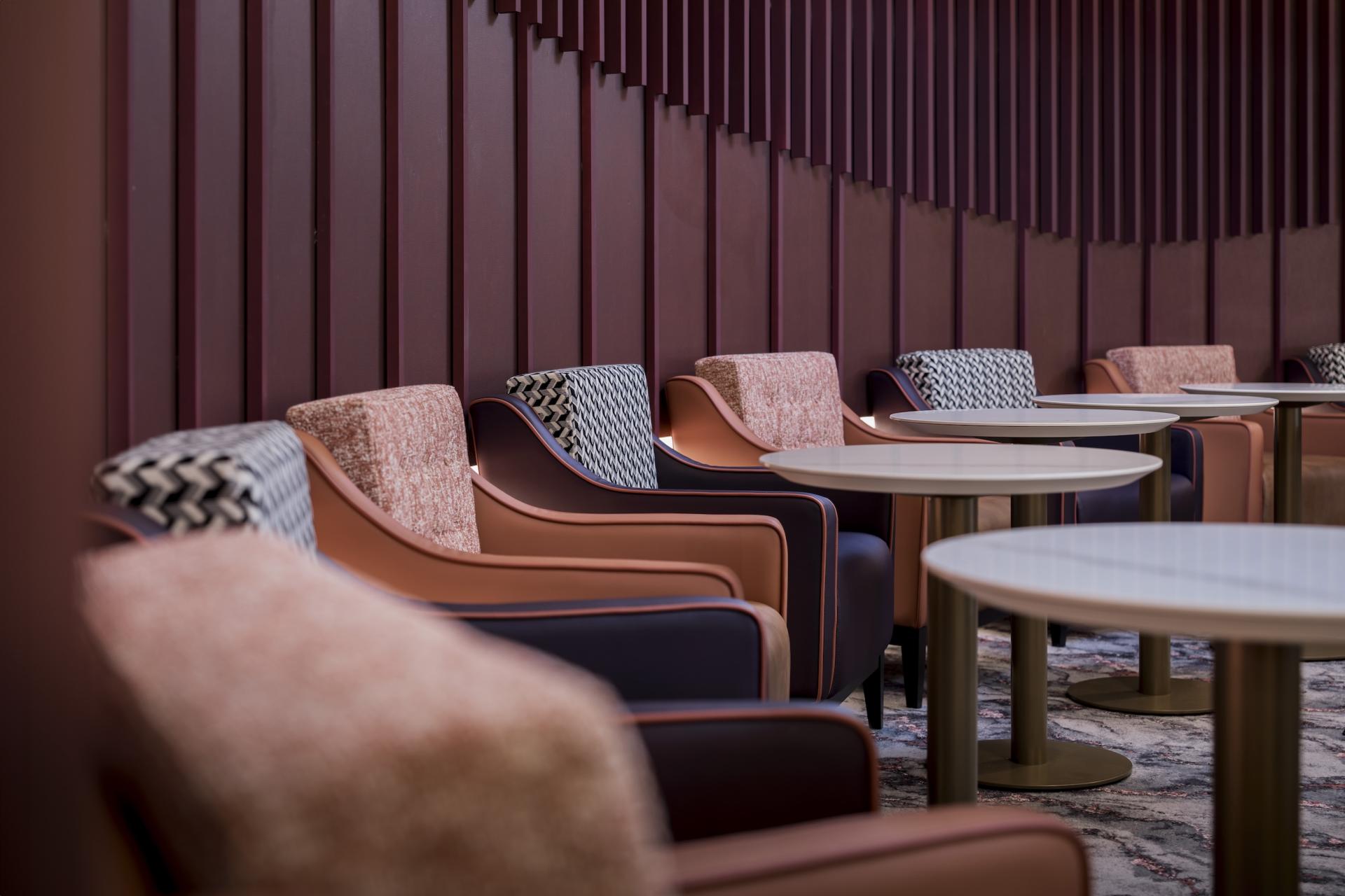 Stylish lounge area with modern seating and tables designed for aviation project discussions at Manchester Airport.
