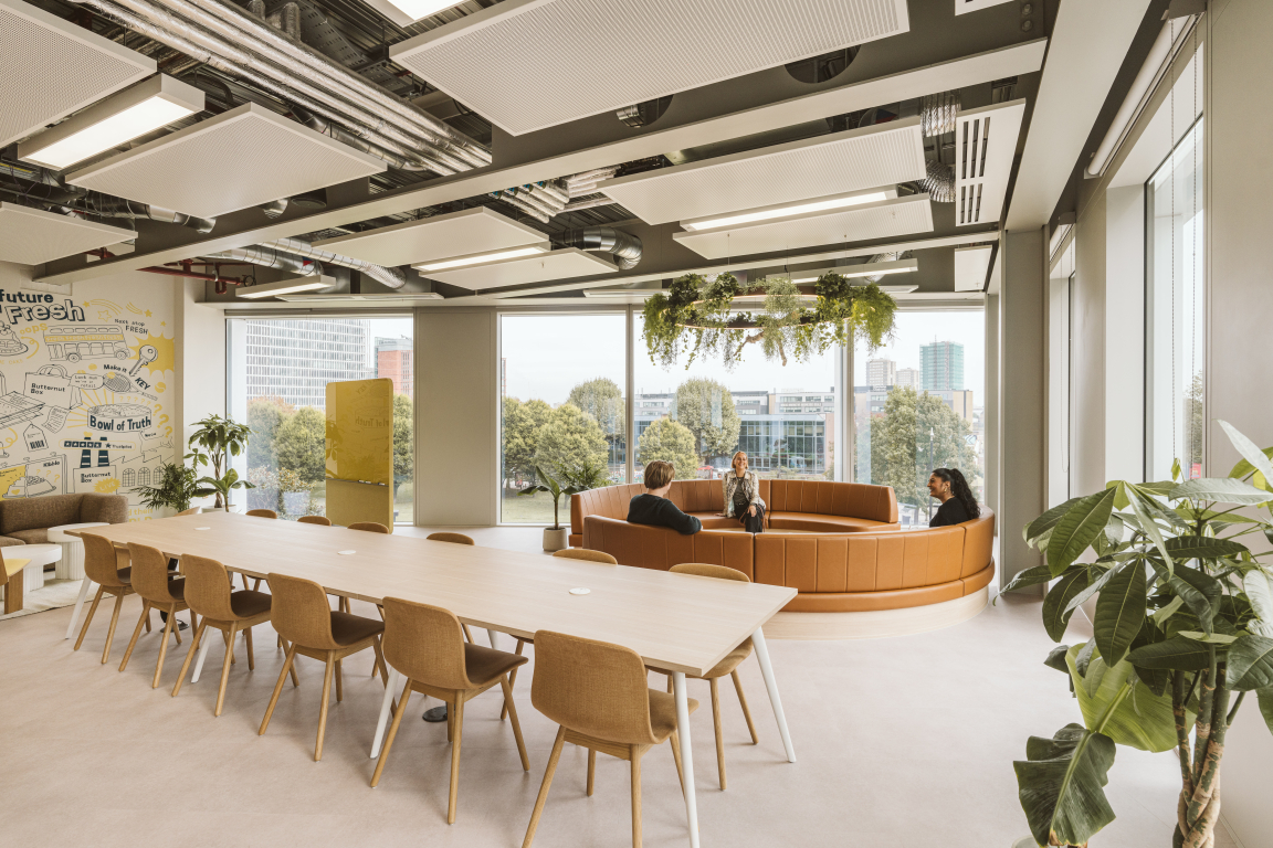 Modern workspace featuring a circular lounge area and a long table, designed for collaboration at Butternut Box.