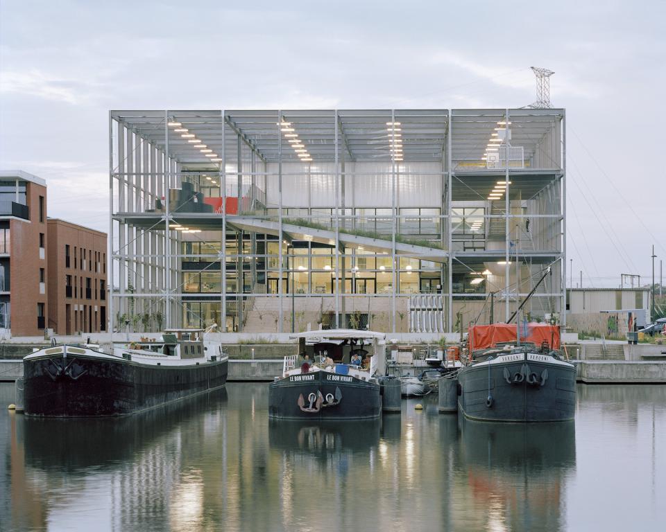 New multipurpose school building by Xaveer De Geyter Architects, overlooking docked boats in the Koopvaardijlaan harbour area.