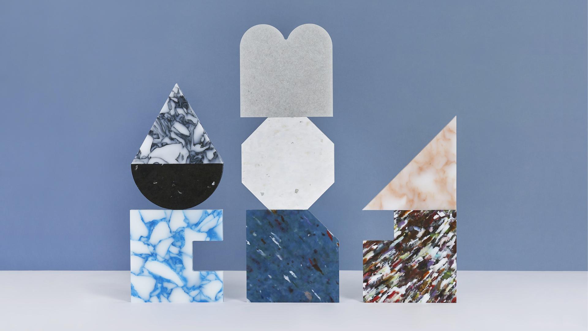 Colorful geometric marble shapes displayed against a blue background, showcasing innovative design at Material Matters, London Design Festival 2023.