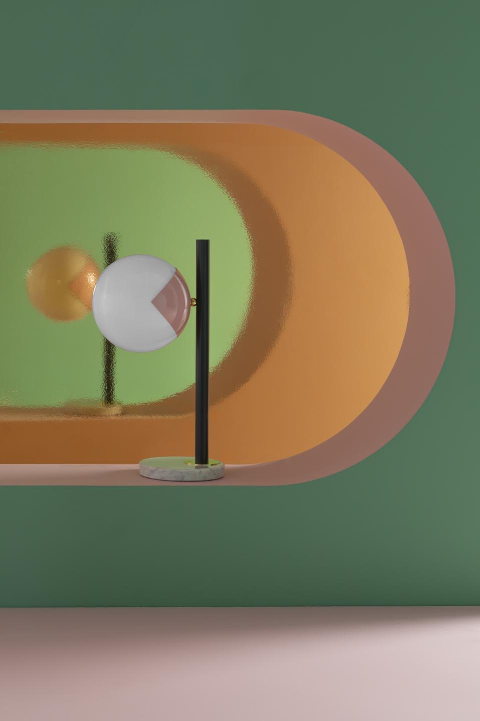 Colorful 'eyeball' lamp design with a glossy base, featuring geometric shapes and modern aesthetics against a vibrant background.