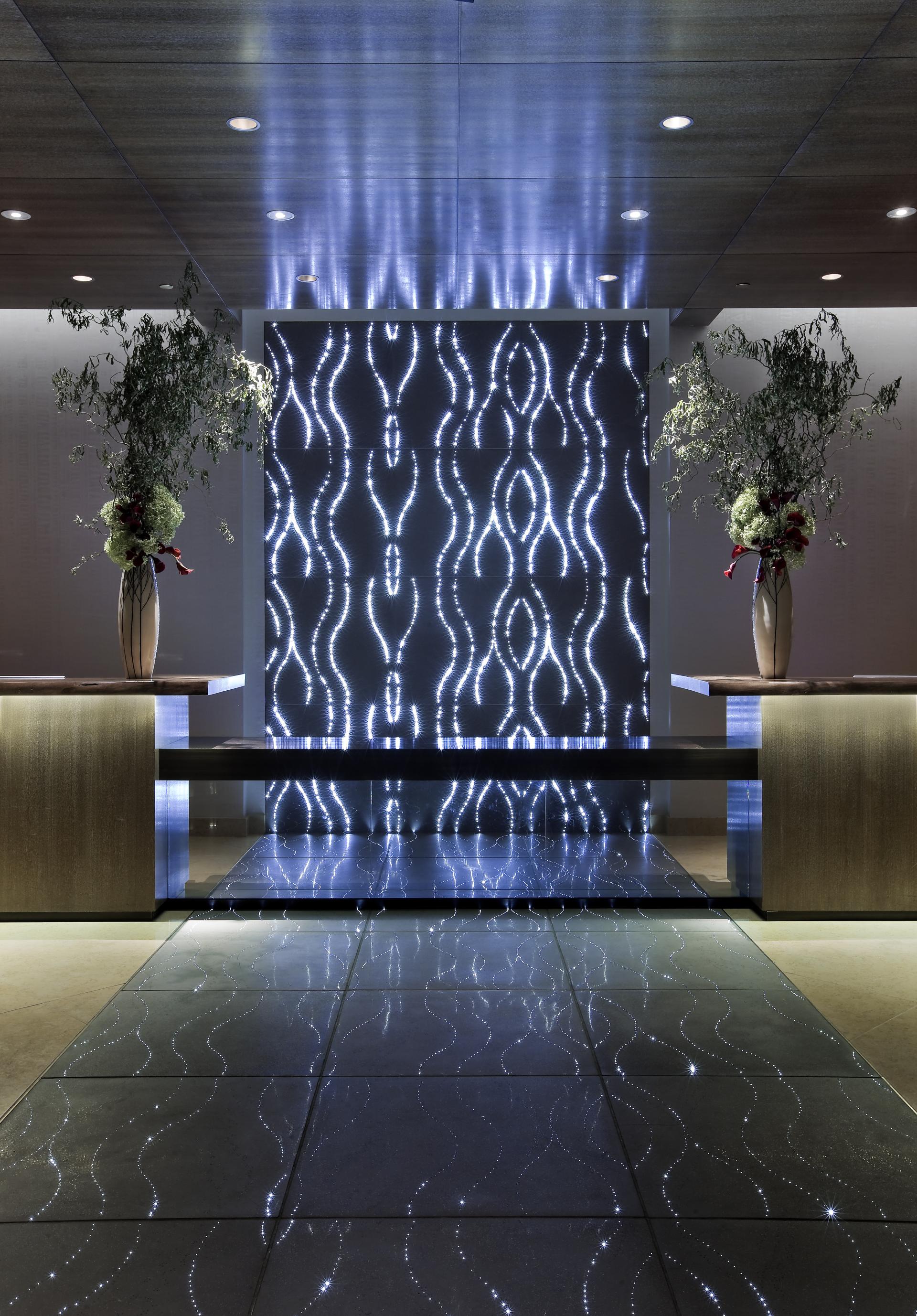 Illuminated wall design with dynamic patterns and reflective surfaces, showcasing Sensitile Systems' innovative use of light and material.