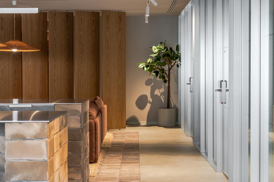 Modern office interior featuring flexible workspace design with natural lighting and greenery for enhanced employee wellbeing.