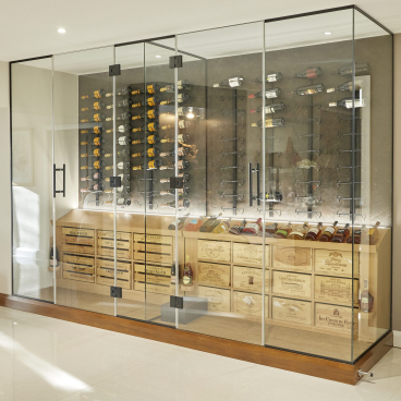 Elegant glass wine room featuring wooden storage crates and a stylish display of various wine bottles.