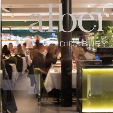 Stylish interior view of Albert's Didsbury, showcasing dining patrons amidst a vibrant, modern atmosphere.