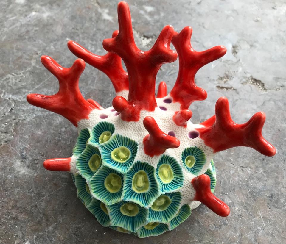 Brightly colored clay sculpture resembling coral, featuring vibrant red branches and textured sea-inspired details, showcasing Lisa Stevens’ artistry.