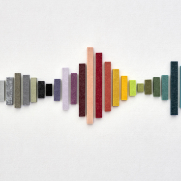 Colorful EchoPanel® acoustic samples arranged in a wave design, celebrating Woven Image's 15-year milestone.