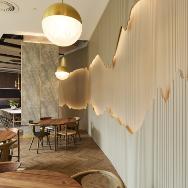Modern amenity space designed by SpaceInvader, featuring stylish furniture, green plants, and an artistic wall design.