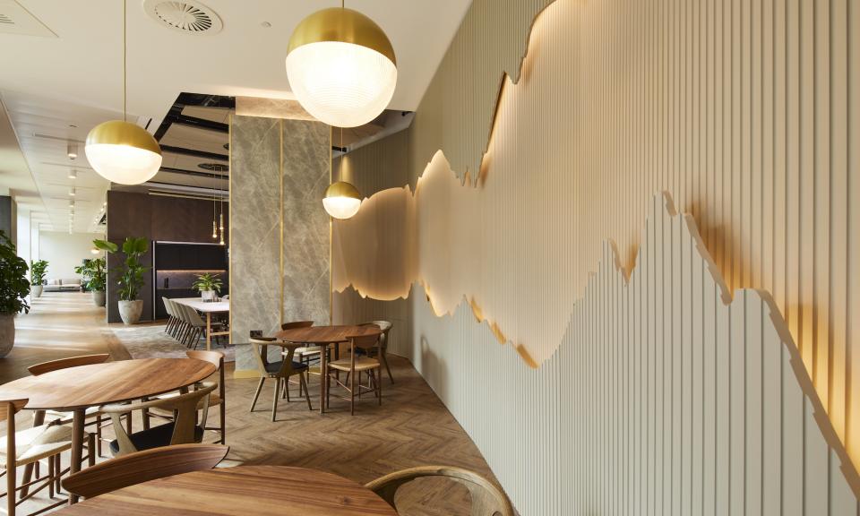 Modern amenity space designed by SpaceInvader, featuring stylish furniture, green plants, and an artistic wall design.