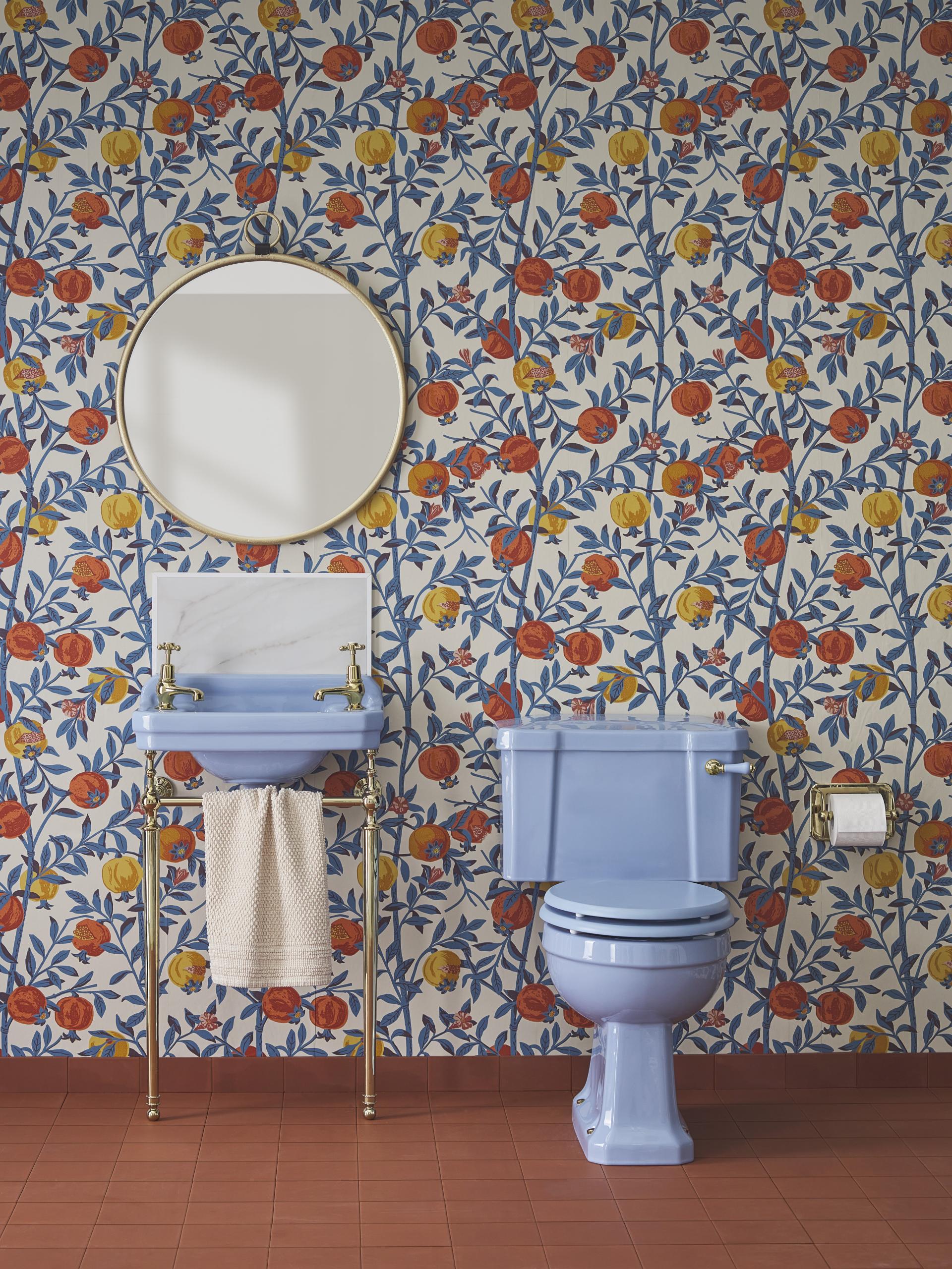 Stylish bathroom featuring Enchanted Blue ceramic fixtures and a vibrant floral wallpaper design.