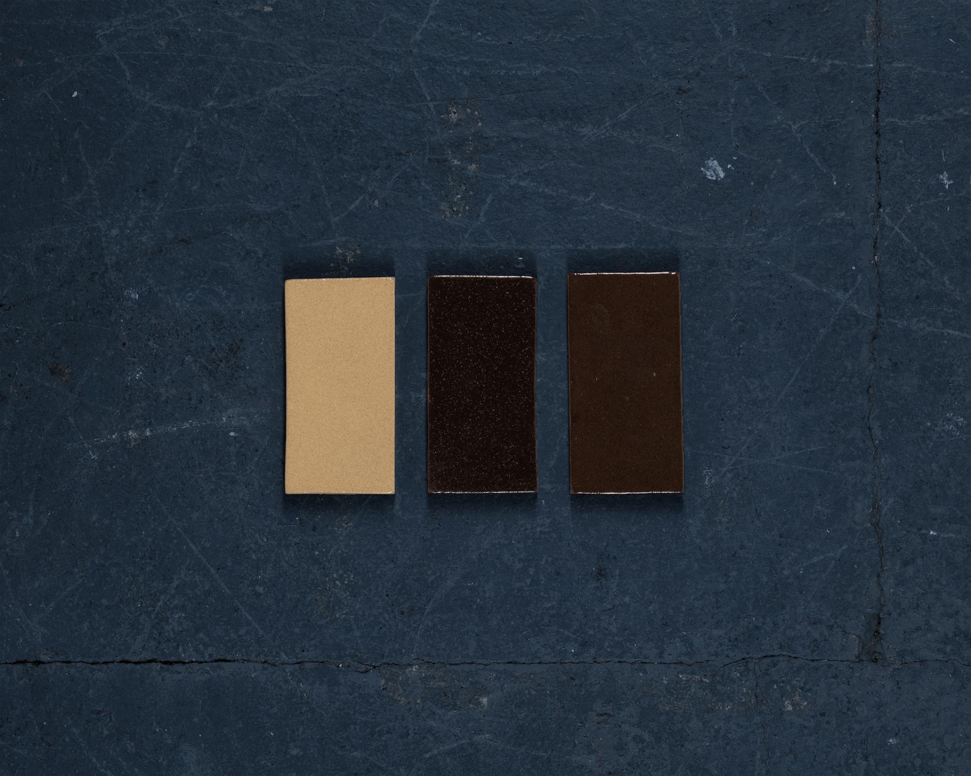 Samples of sustainable tiles made from London’s waste, showcasing three color variations on a textured surface.