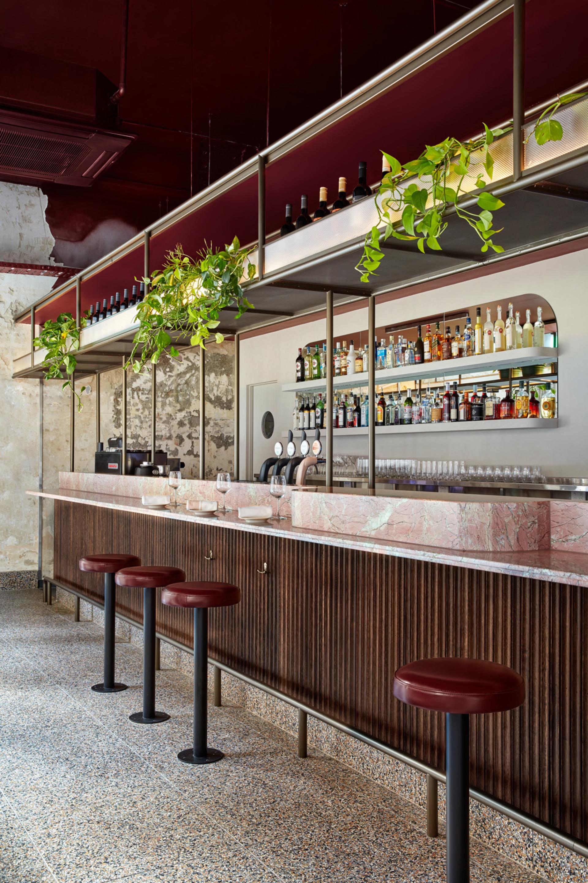 Pentolina restaurant bar featuring elegant marble countertops, stylish seating, and a vibrant selection of Italian spirits and drinks.