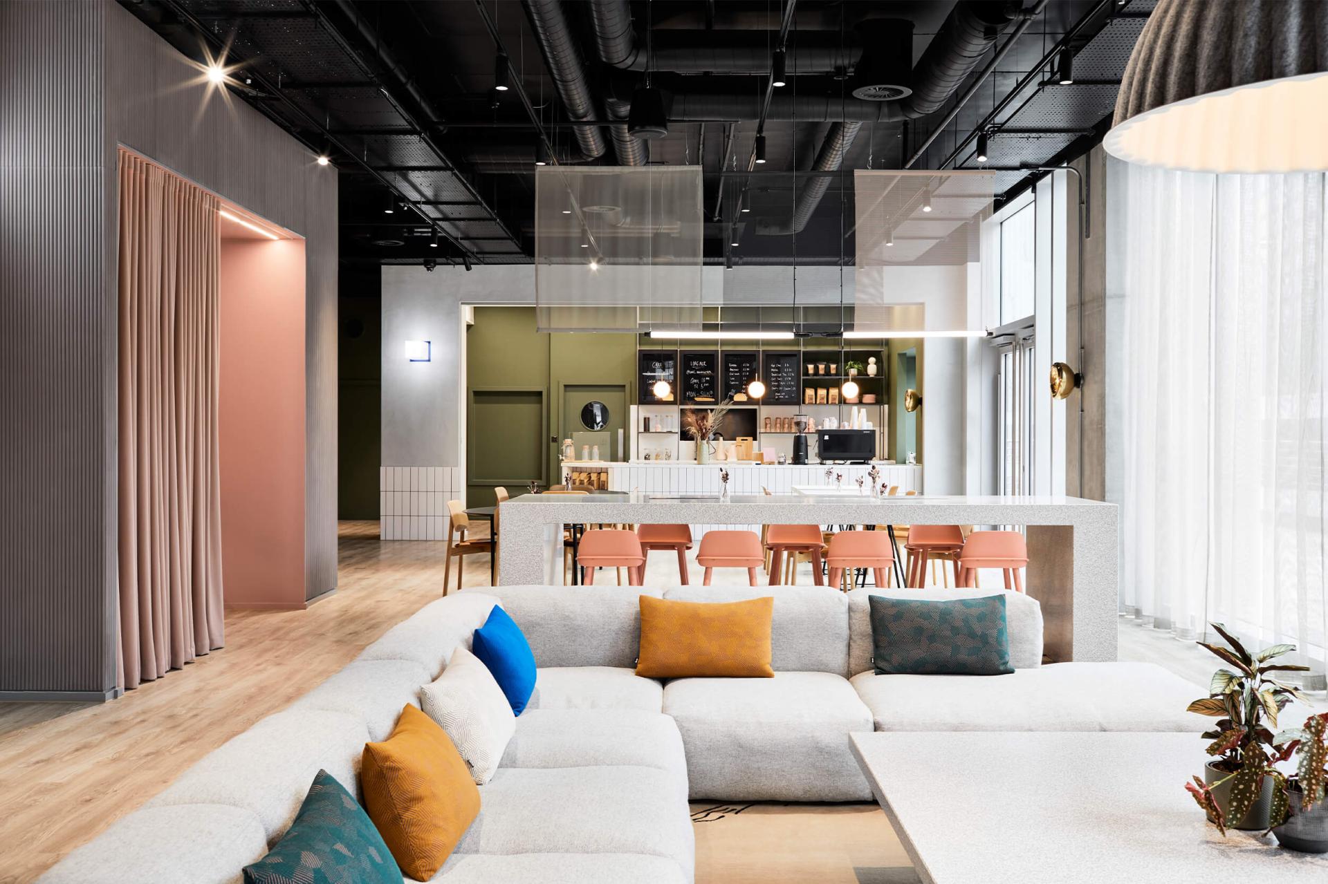 Modern interior design showcasing a cozy lounge area with a stylish sofa and a vibrant café setting.