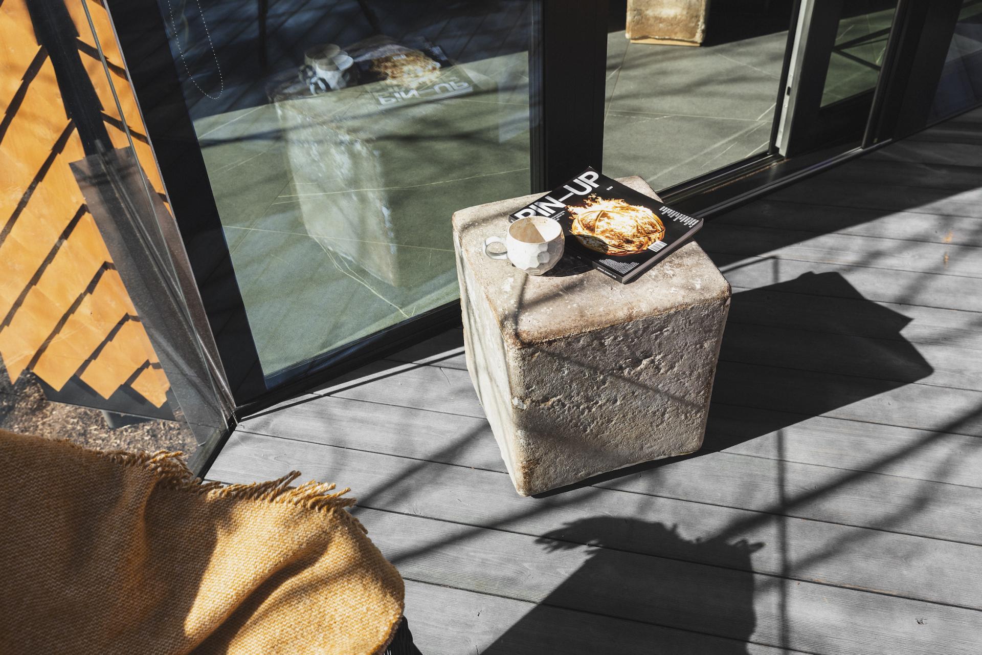 Sustainable mycelium material used as a unique side table, complemented by a coffee cup and magazine.