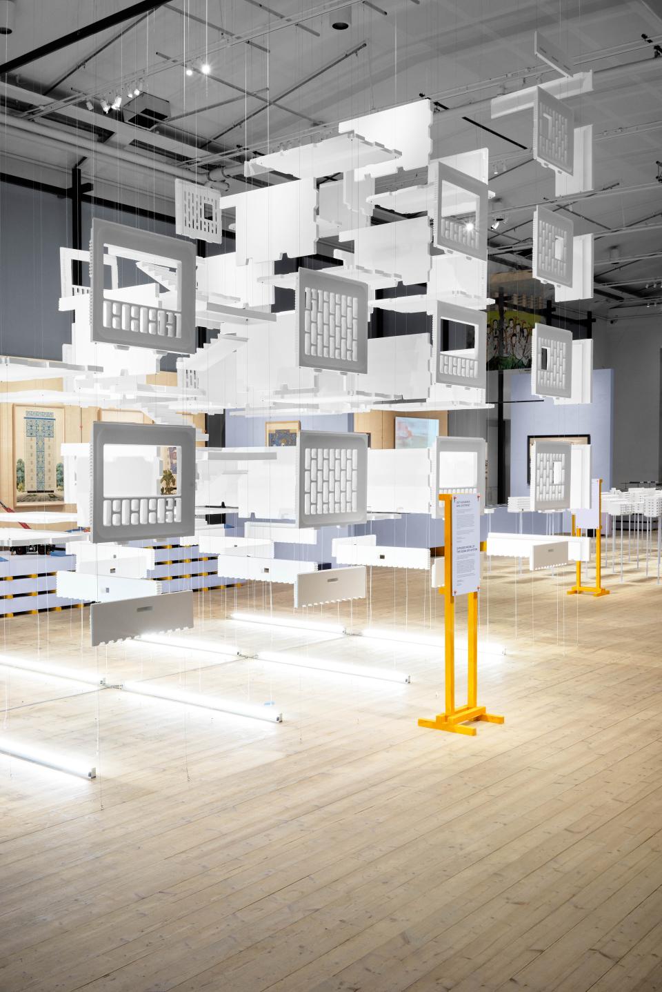 Hanging architectural models illustrate the evolution of concrete design in the ArkDes exhibition, showcasing post-war urban reconstruction.