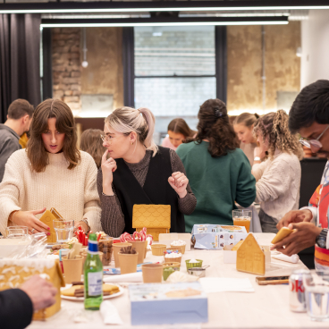 Participants engaged in a creative gingerbread house decorating workshop at Material Source Studio in Manchester.
