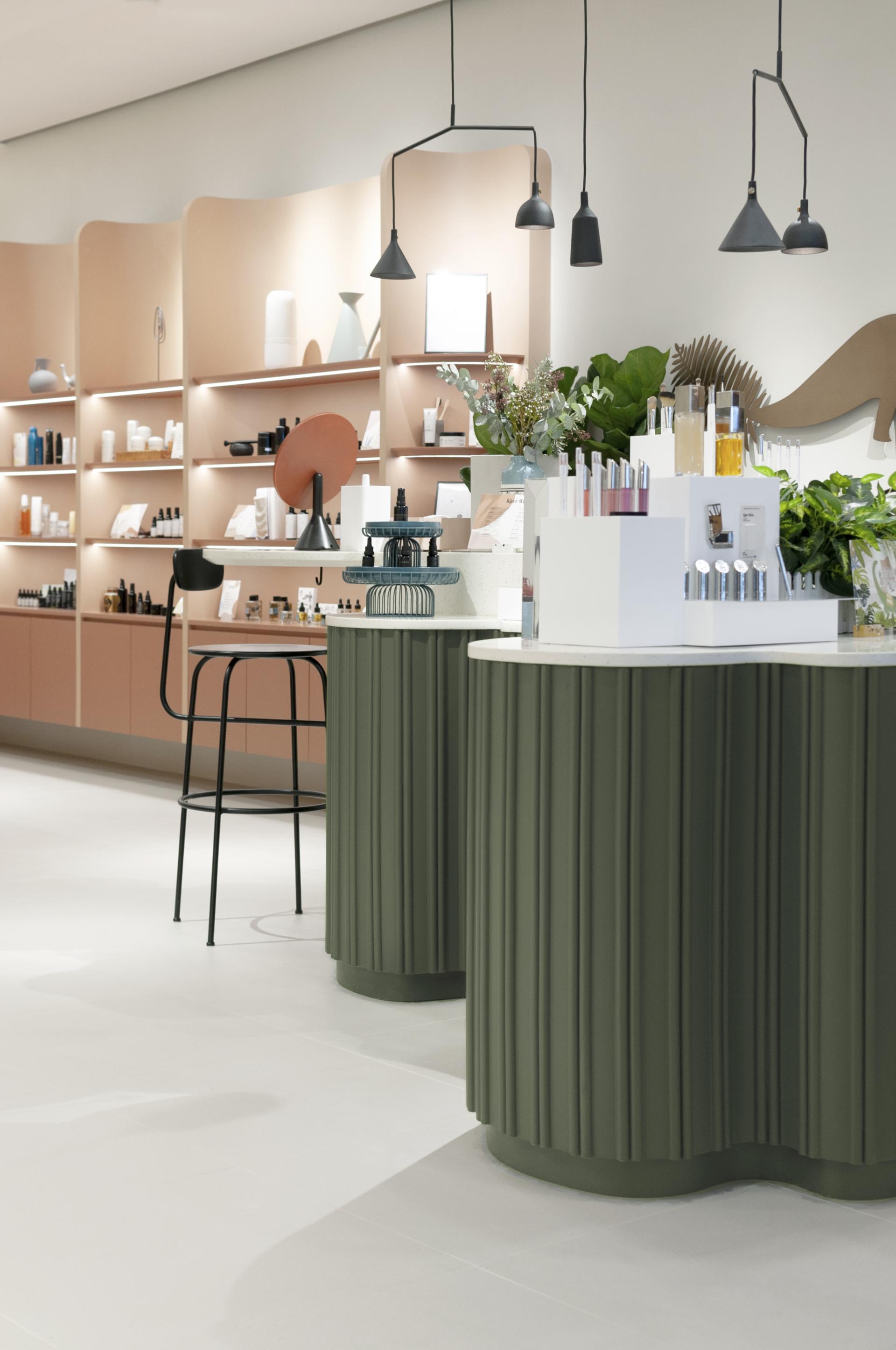 Stylish interior of an organic skincare store featuring soft curves, sculptural displays, and modern lighting elements.