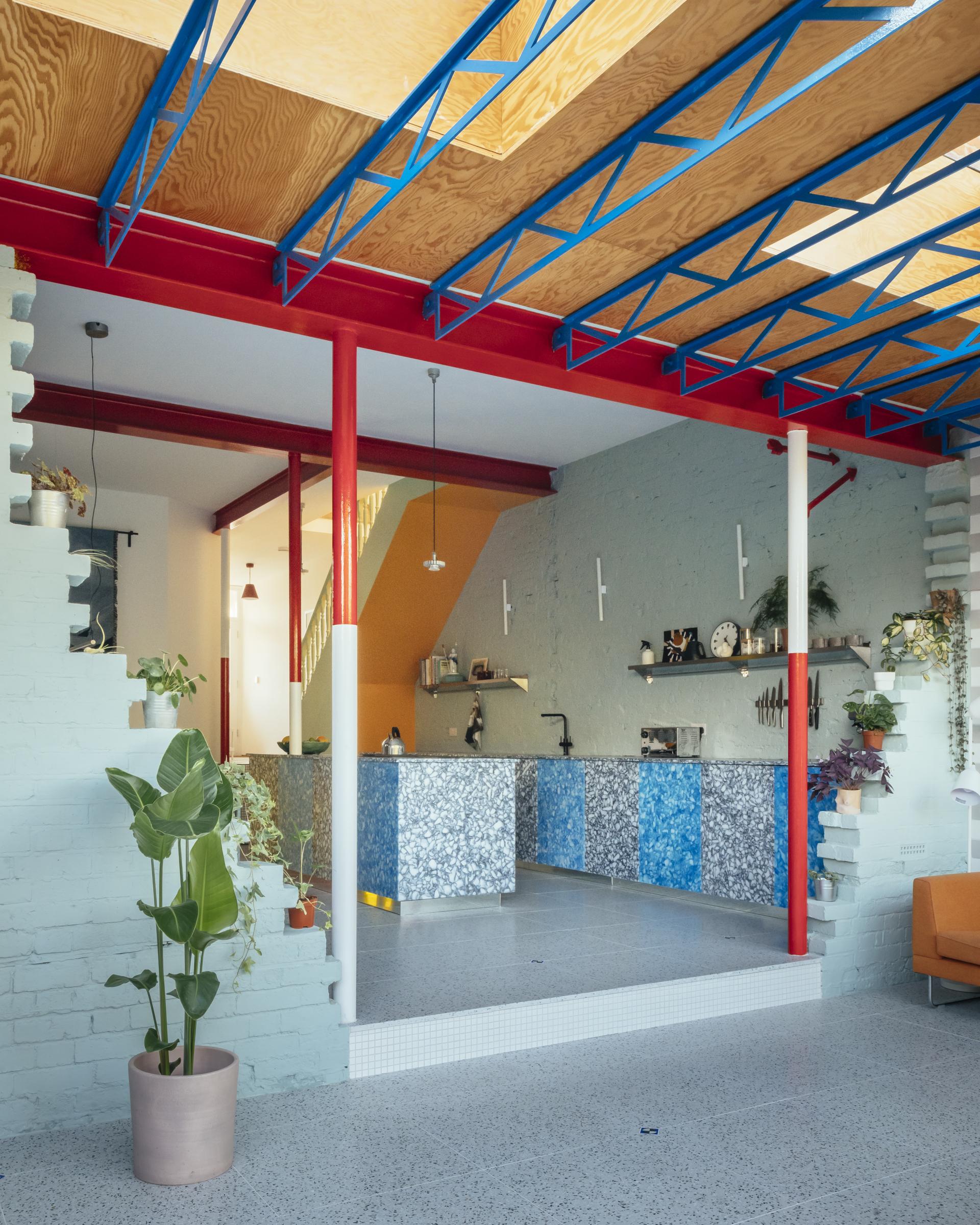 Vibrant interior of a redesigned Edwardian house featuring a colorful kitchen, modern decor, and unique architectural elements.