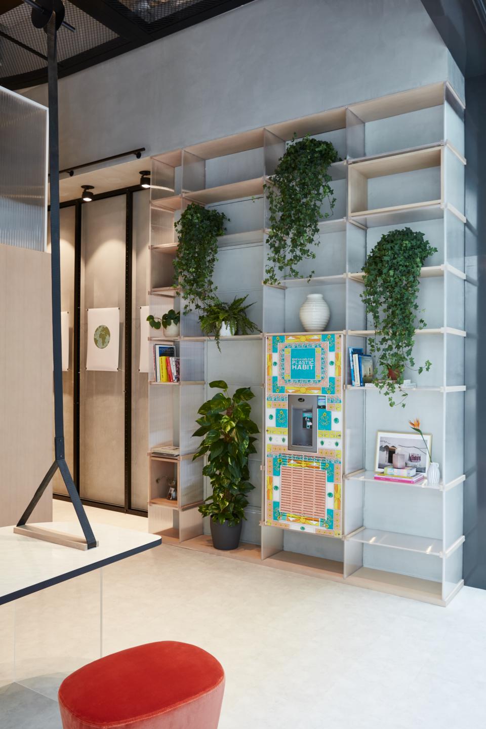 Contemporary interior of Roar Studio in Dubai featuring shelves, plants, and a colorful vending machine in a cultural hub.