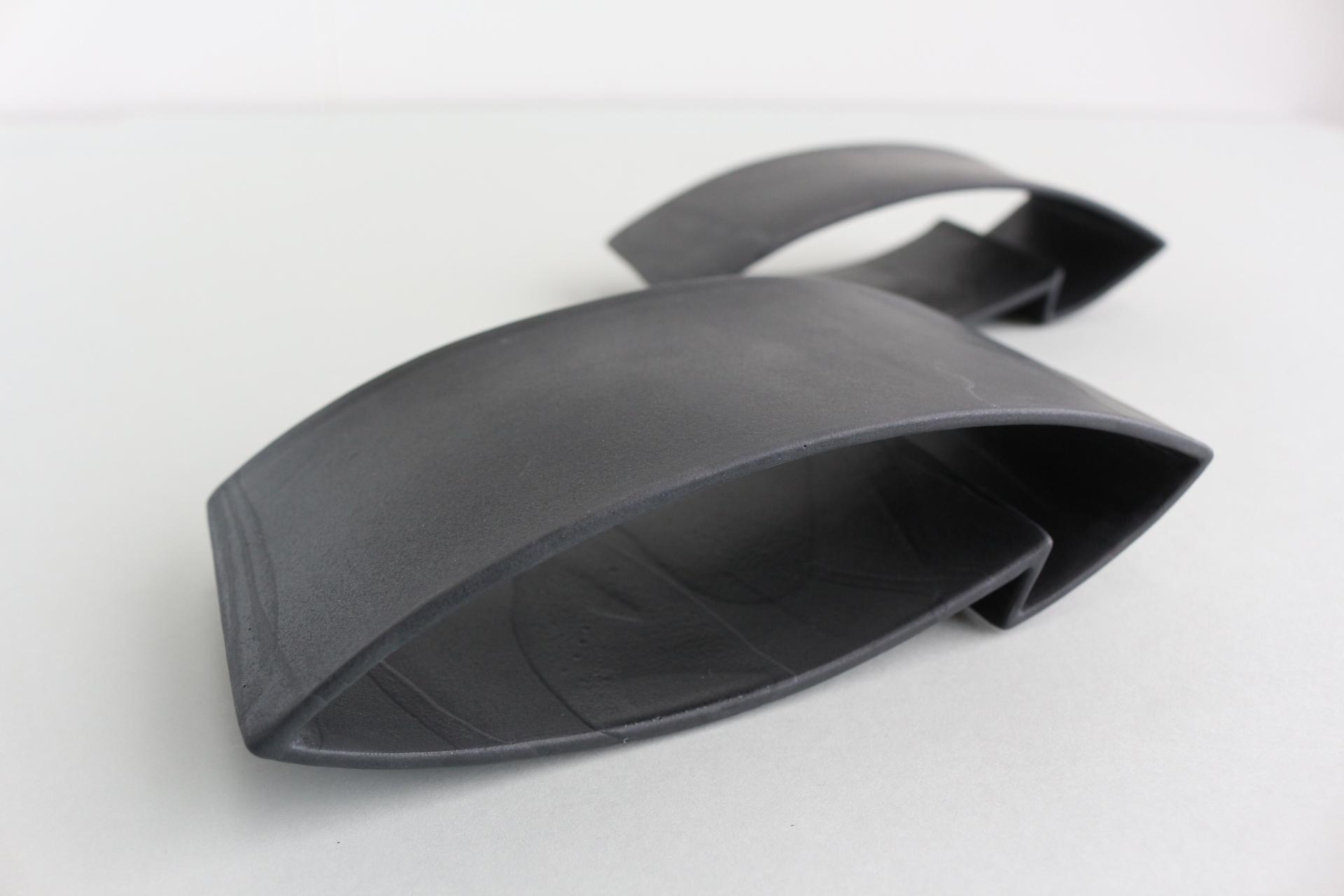 Sleek black ceramic sculpture showcasing innovative design by ceramicist Jo Woffinden at Harewood House Biennial.