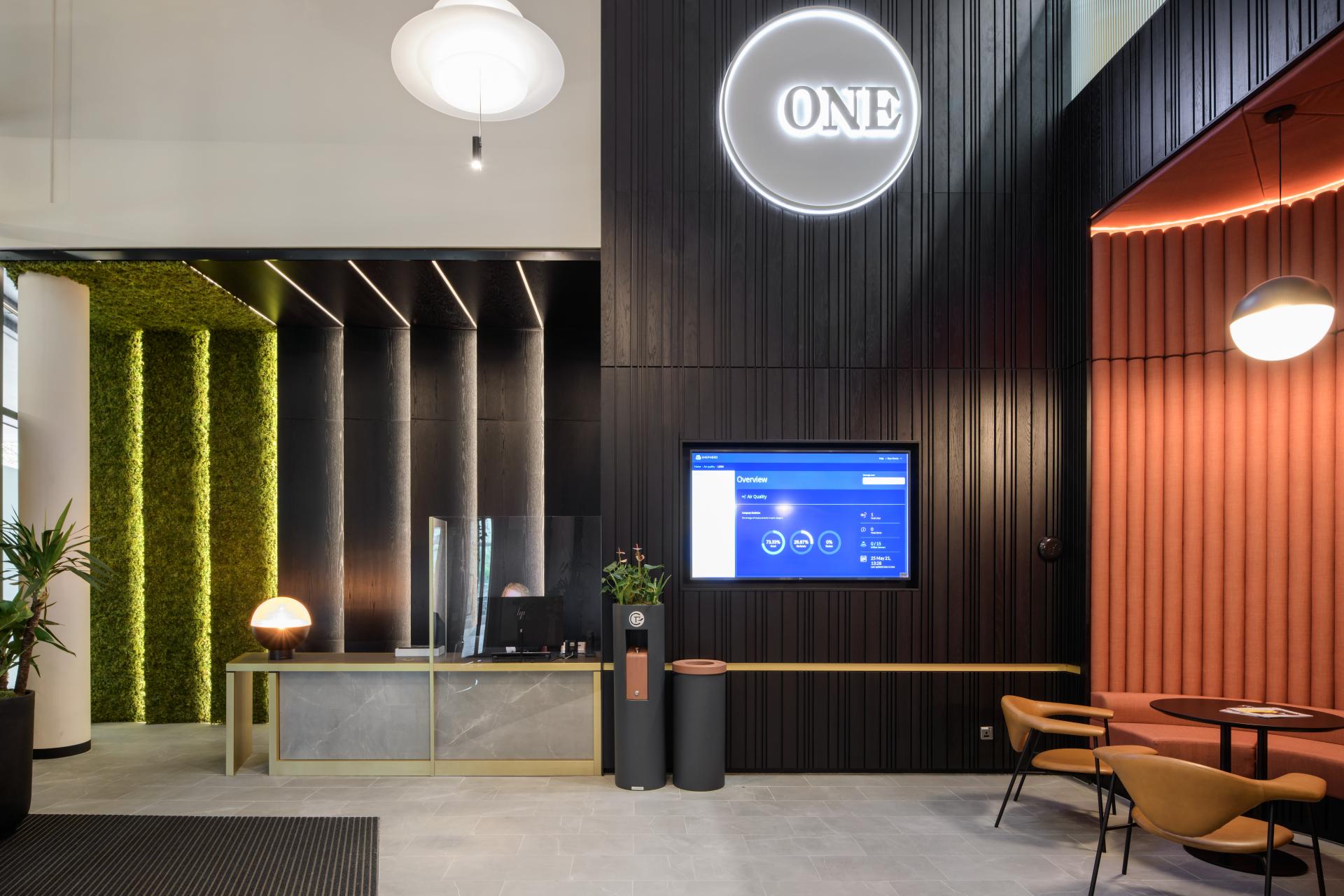 Modern reception area at One Piccadilly Gardens featuring sleek design, greenery, and digital display, transformed by SpaceInvader.