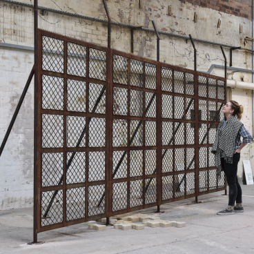 Tana West’s (UN)WOVEN installation features a large, rusted metal barrier, symbolizing divisions across Europe.