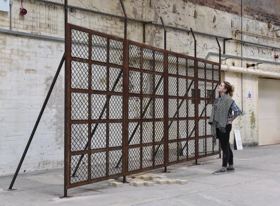 Tana West’s (UN)WOVEN installation features a large, rusted metal barrier, symbolizing divisions across Europe.