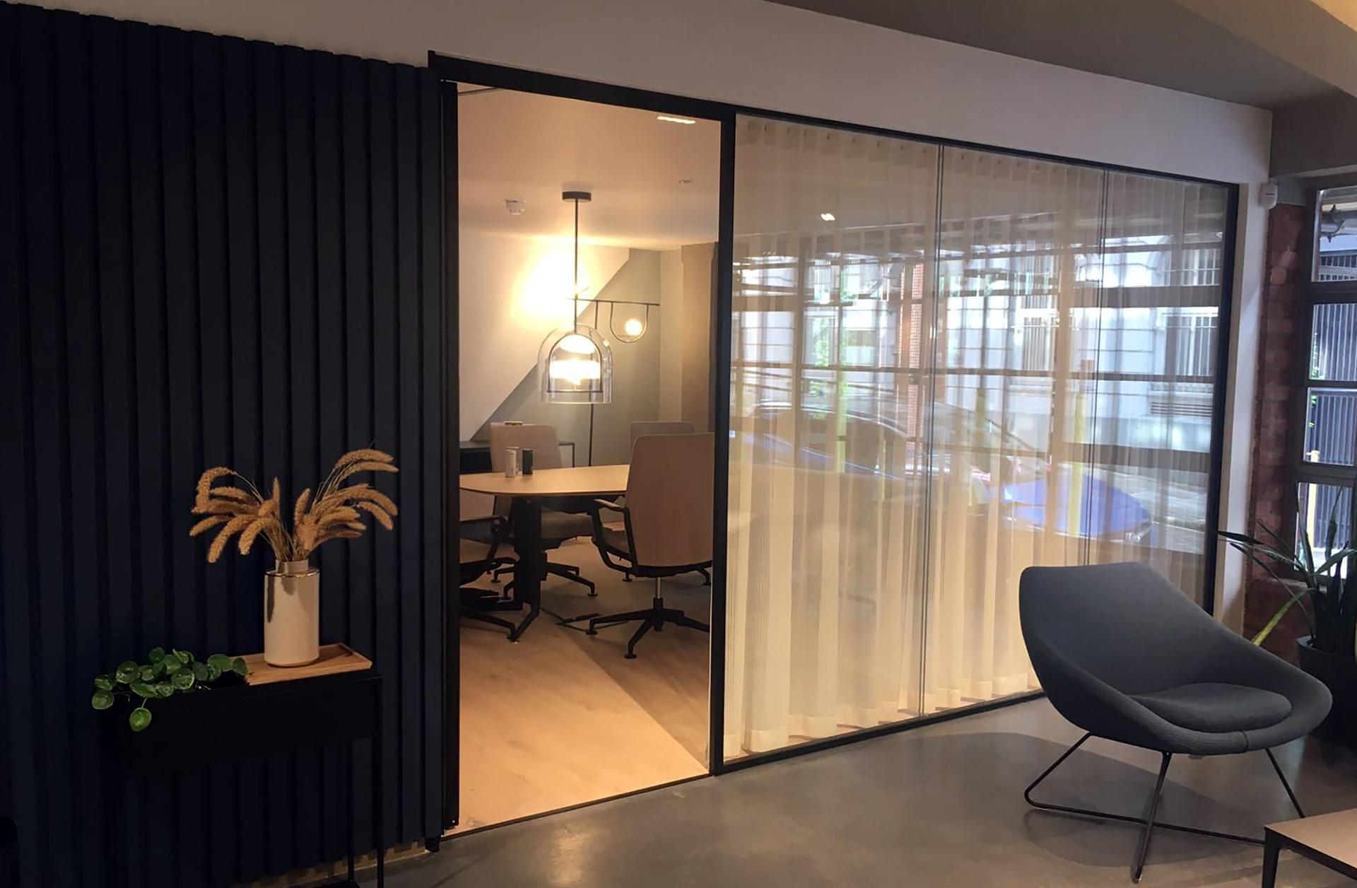 Modern workspace with glass walls, stylish furnishings, and a conference table, reflecting the rise of flexible working environments.