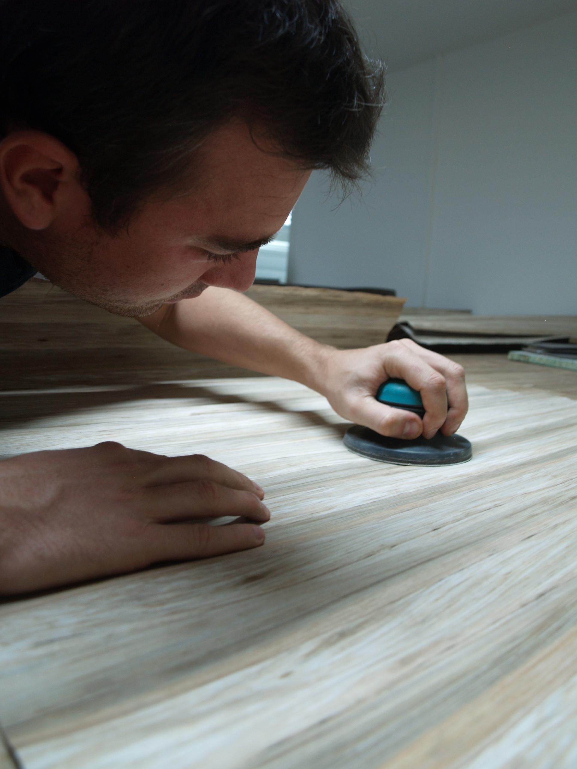 Craftsman smoothing a surface made from recycled banana plant trunks at FIBandCO in Martinique.
