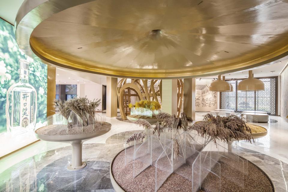 Interactive sensory display featuring natural elements and baijiu branding in a modern Chinese liquor factory setting.