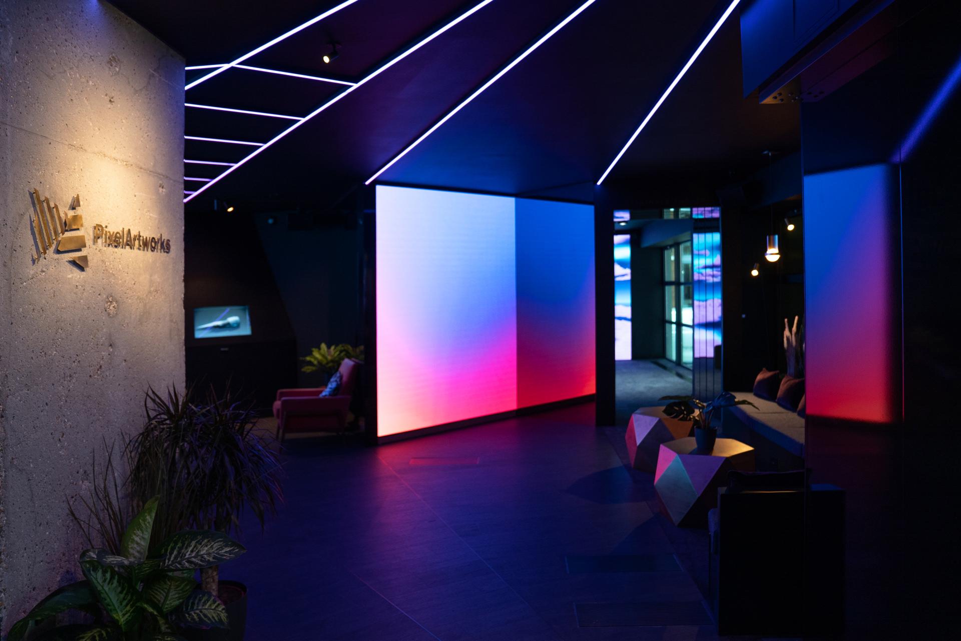 Futuristic interior of Pixel Artworks showroom featuring dynamic LED screens and sleek design elements.