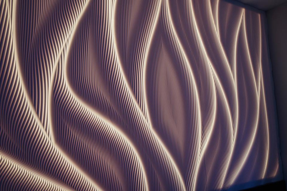 Stylish wall surface design featuring undulating lines illuminated by bespoke lighting, showcasing CDUK's M|R Walls innovation.