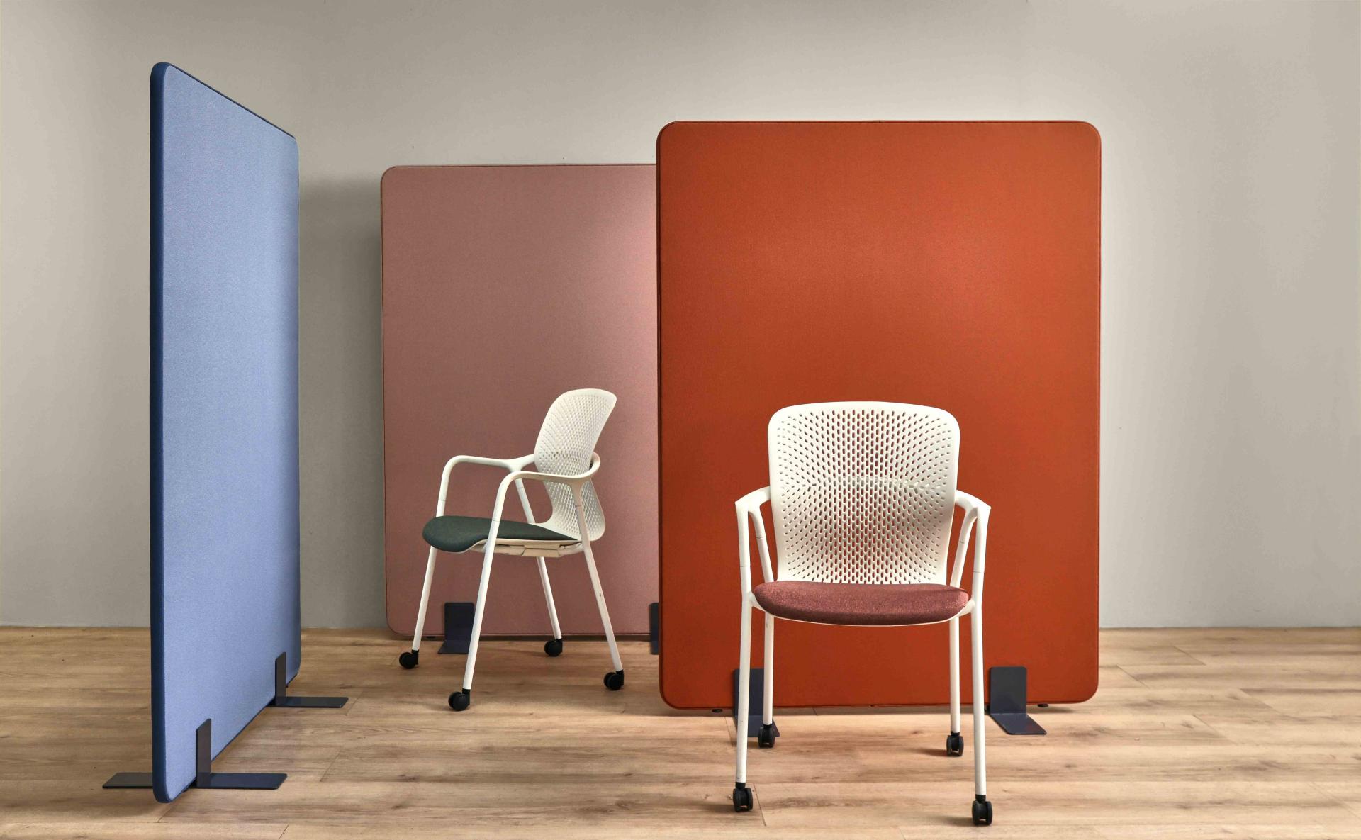 Colorful acoustically transparent textile panels and modern chair created from recycled materials, enhancing sustainable workspace design.