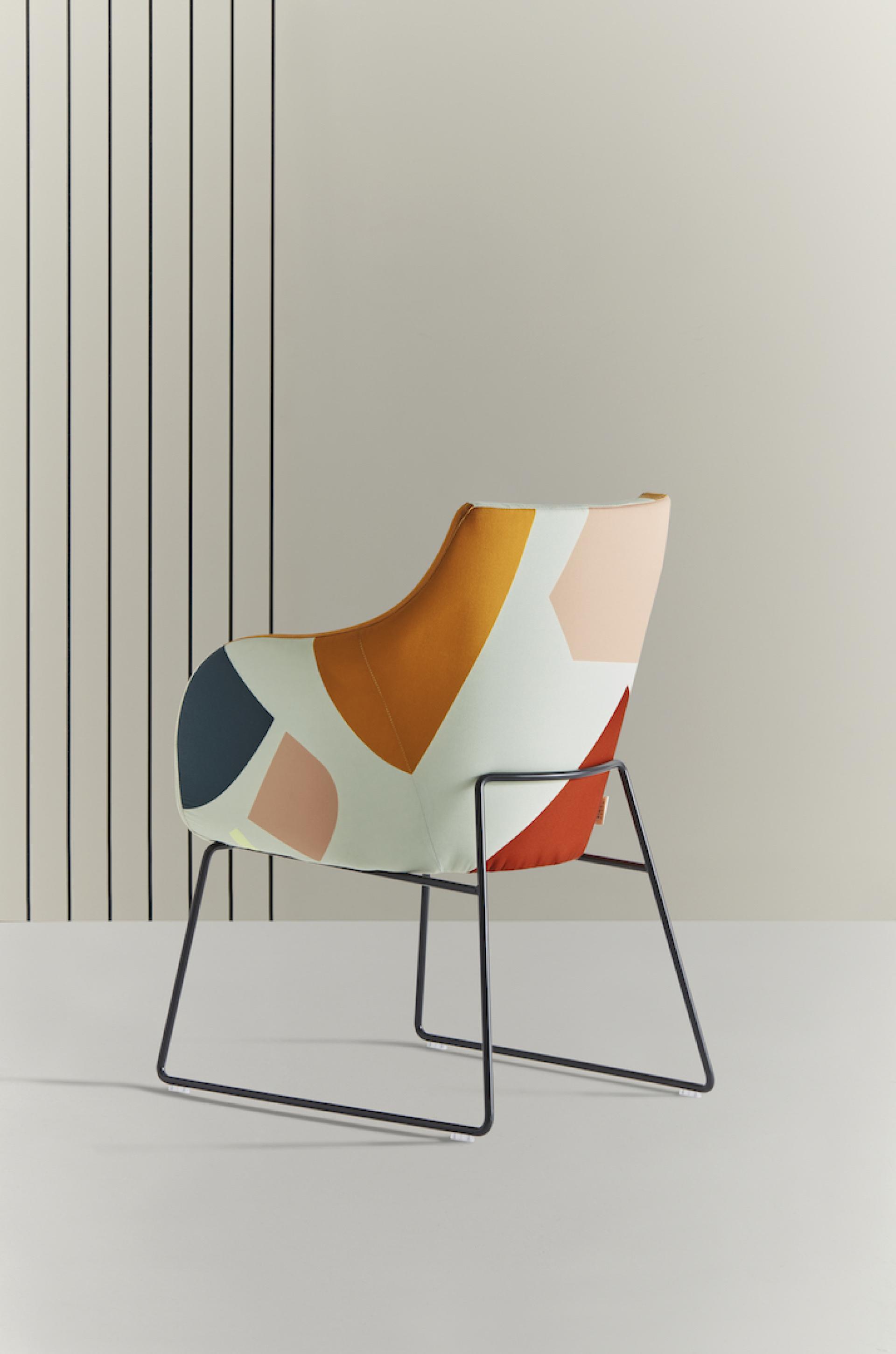 Colorful geometric chair design by Tom Pigeon, featuring a playful pattern, set against a minimalist background.