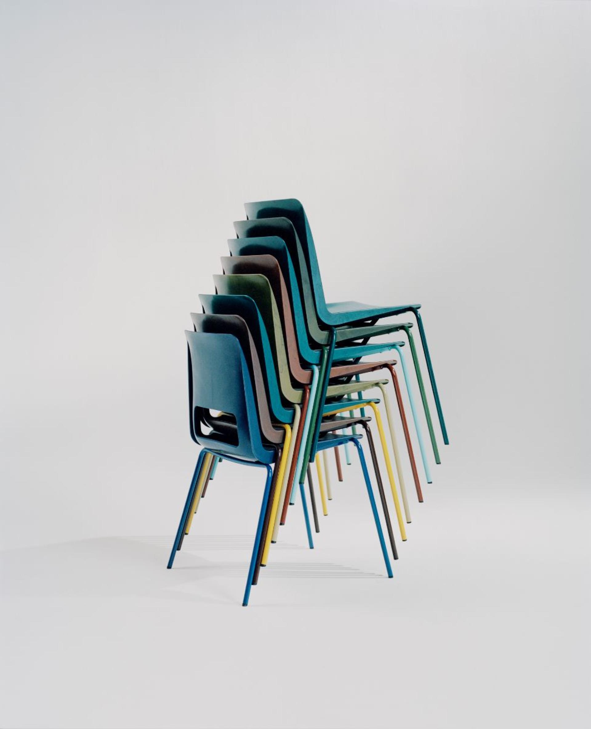 Stacked colorful chairs showcasing Norway's innovative circular-design approach in furniture, emphasizing sustainability and modern design.