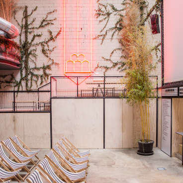 Interior space featuring retro cinema seating and a neon light design, showcasing Plantea's unique interior design approach.