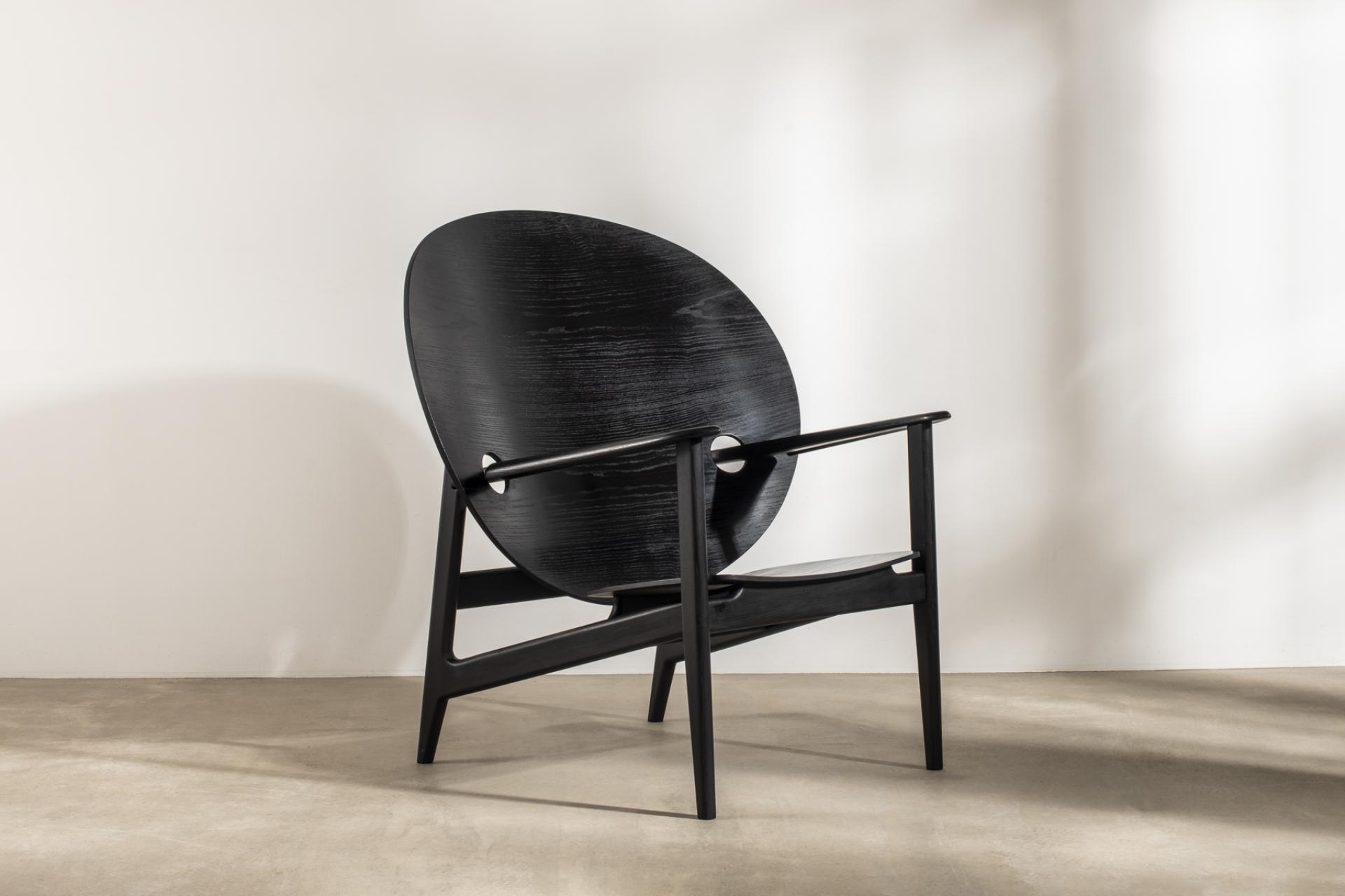 Sleek black designer chair with a round backrest, showcasing modern aesthetics and sustainable design, featured in Harewood Biennial 2022.
