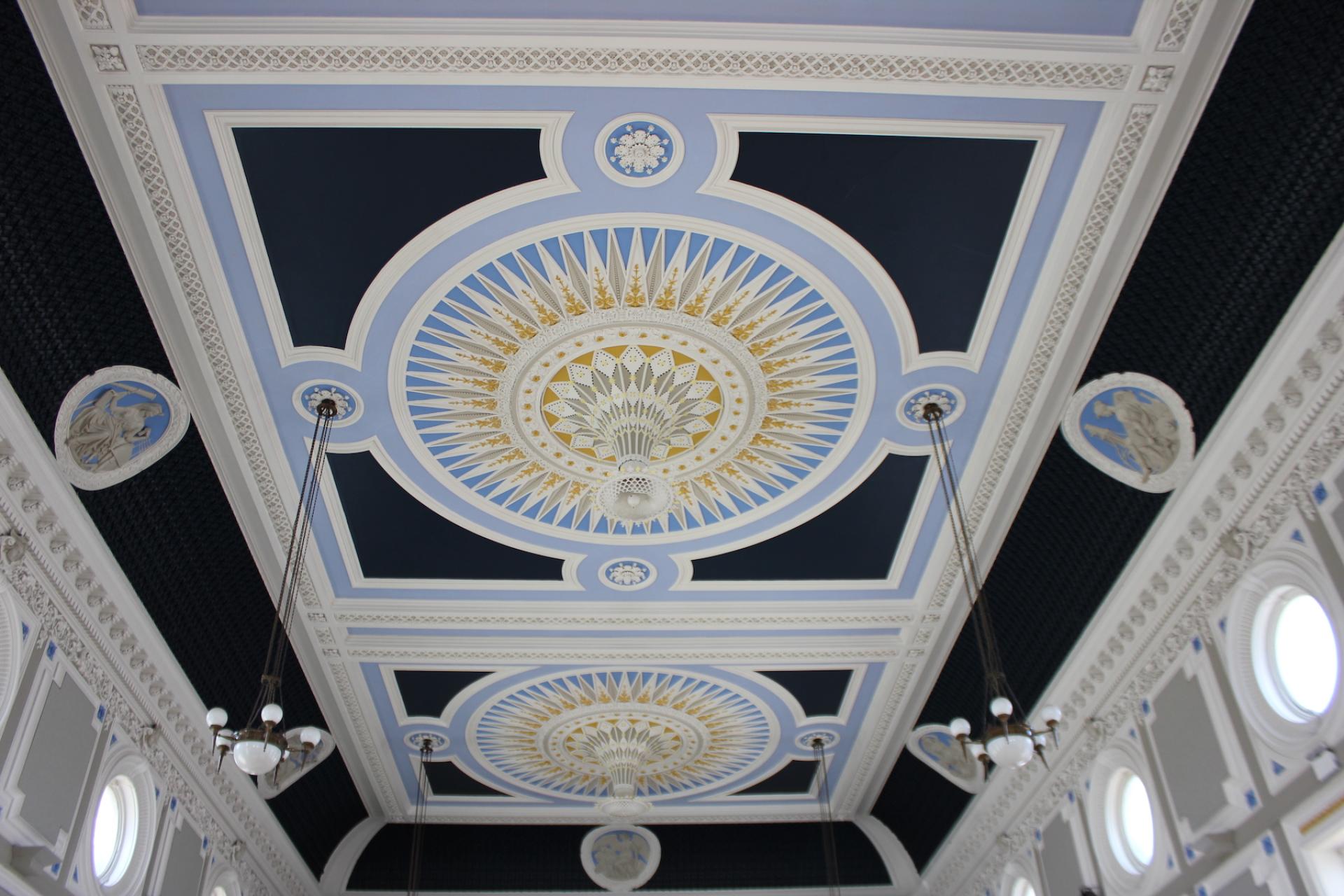Beautifully restored ceiling of Todmorden Town Hall's ballroom, featuring intricate designs and fresh Crown Paints colors.