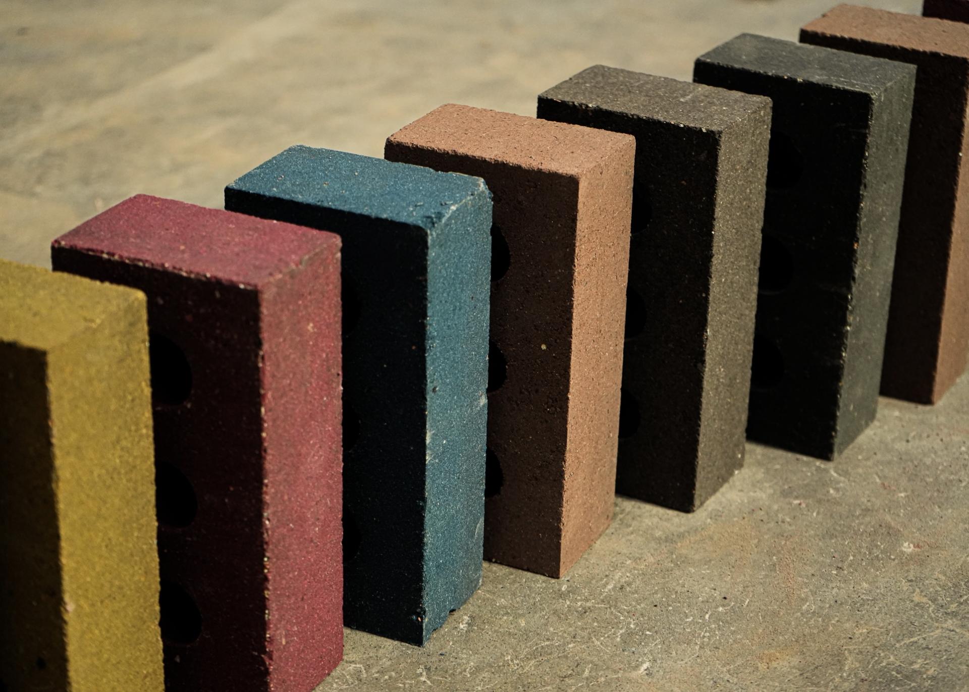 Variation of colorful, un-fired bricks demonstrating low embodied carbon for sustainable construction solutions in the built environment.
