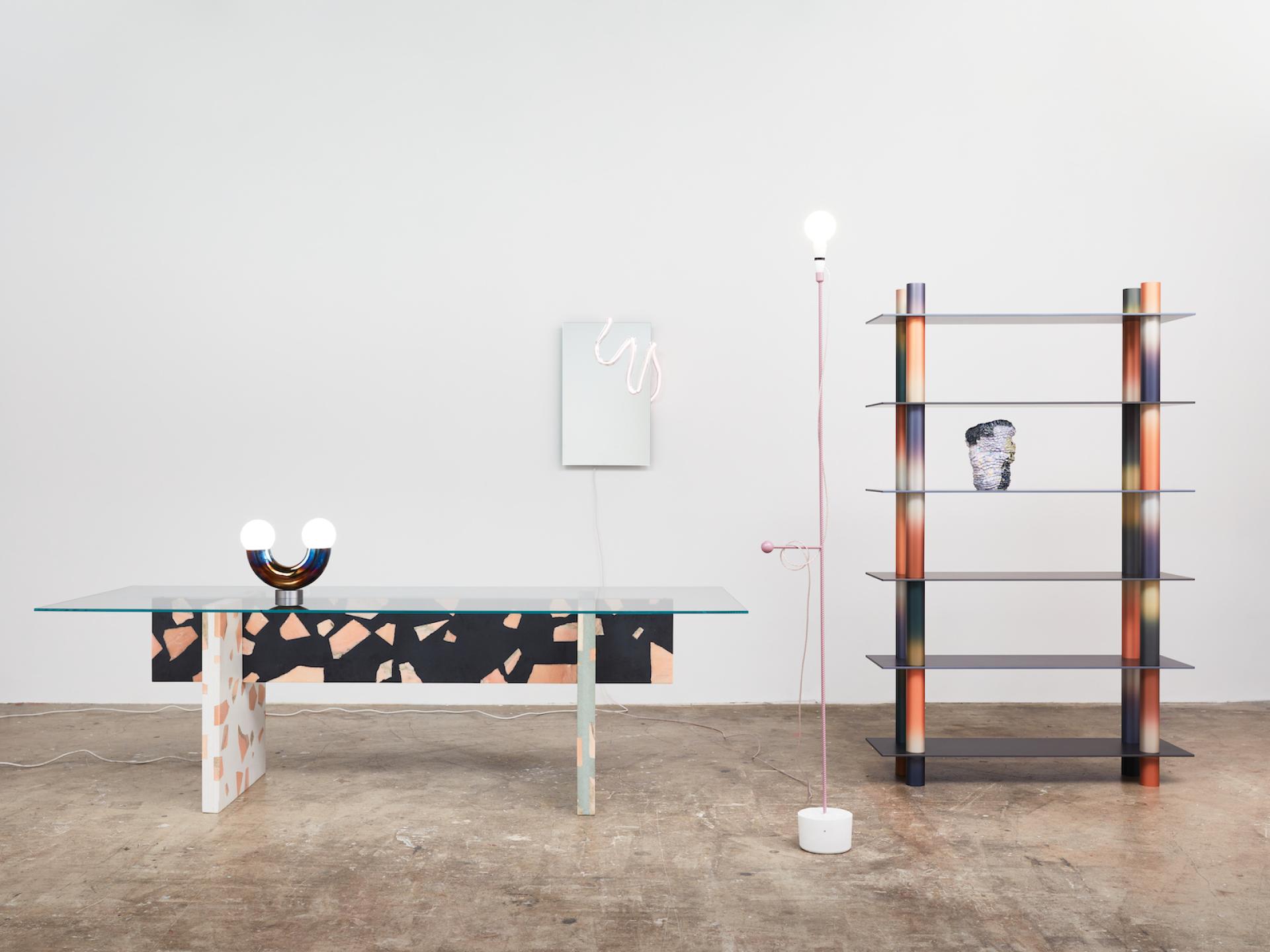 Stylish modern furniture featuring a glass table, unique lamp, and colorful shelving, reflecting Monika Swindells' design aesthetic.