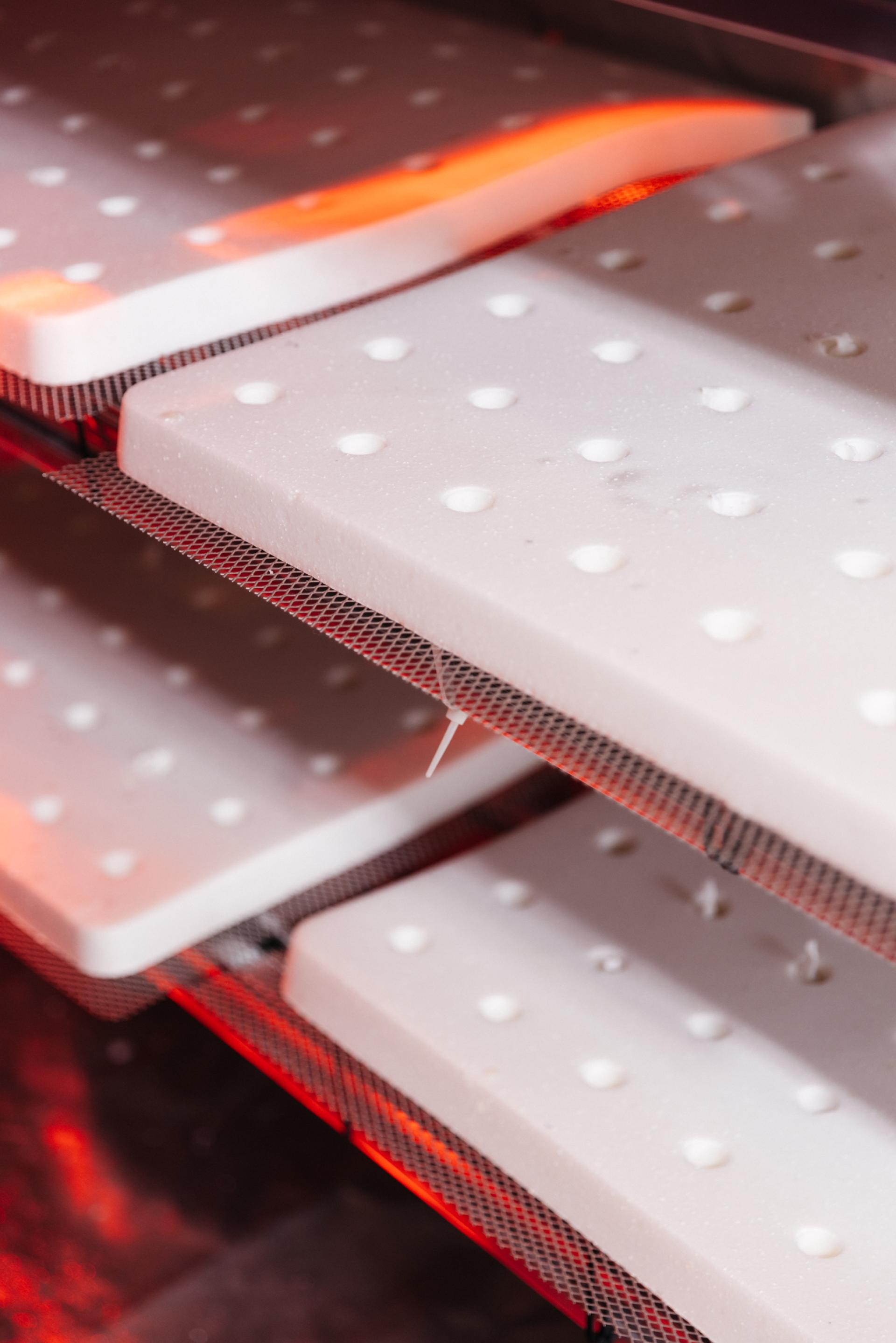 Biomaterial sheets with perforations being processed in a low-carbon manufacturing environment for sustainable product development.