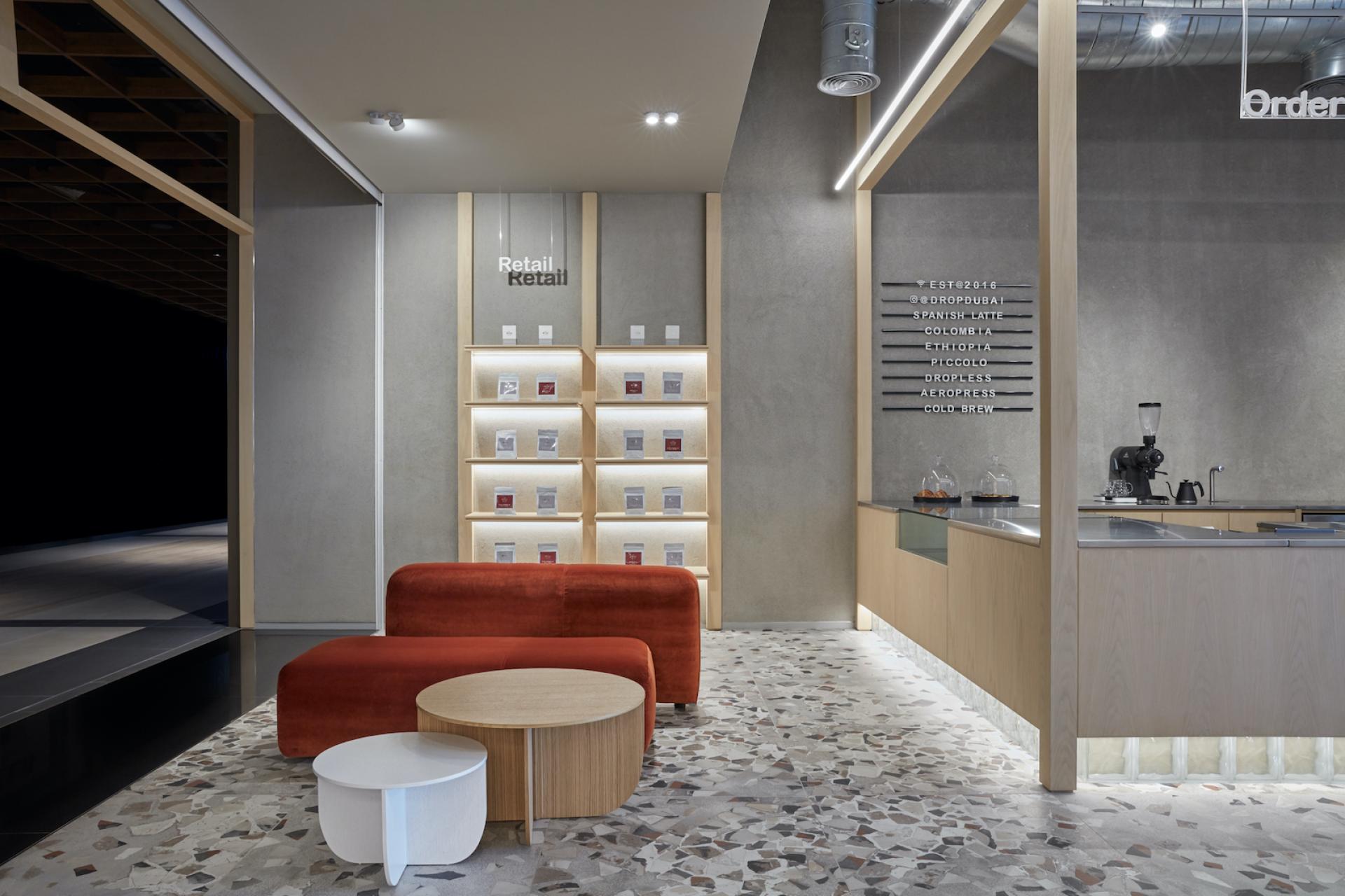 Modern coffee shop interior in Dubai featuring minimalist design, textured surfaces, and a cozy seating area.