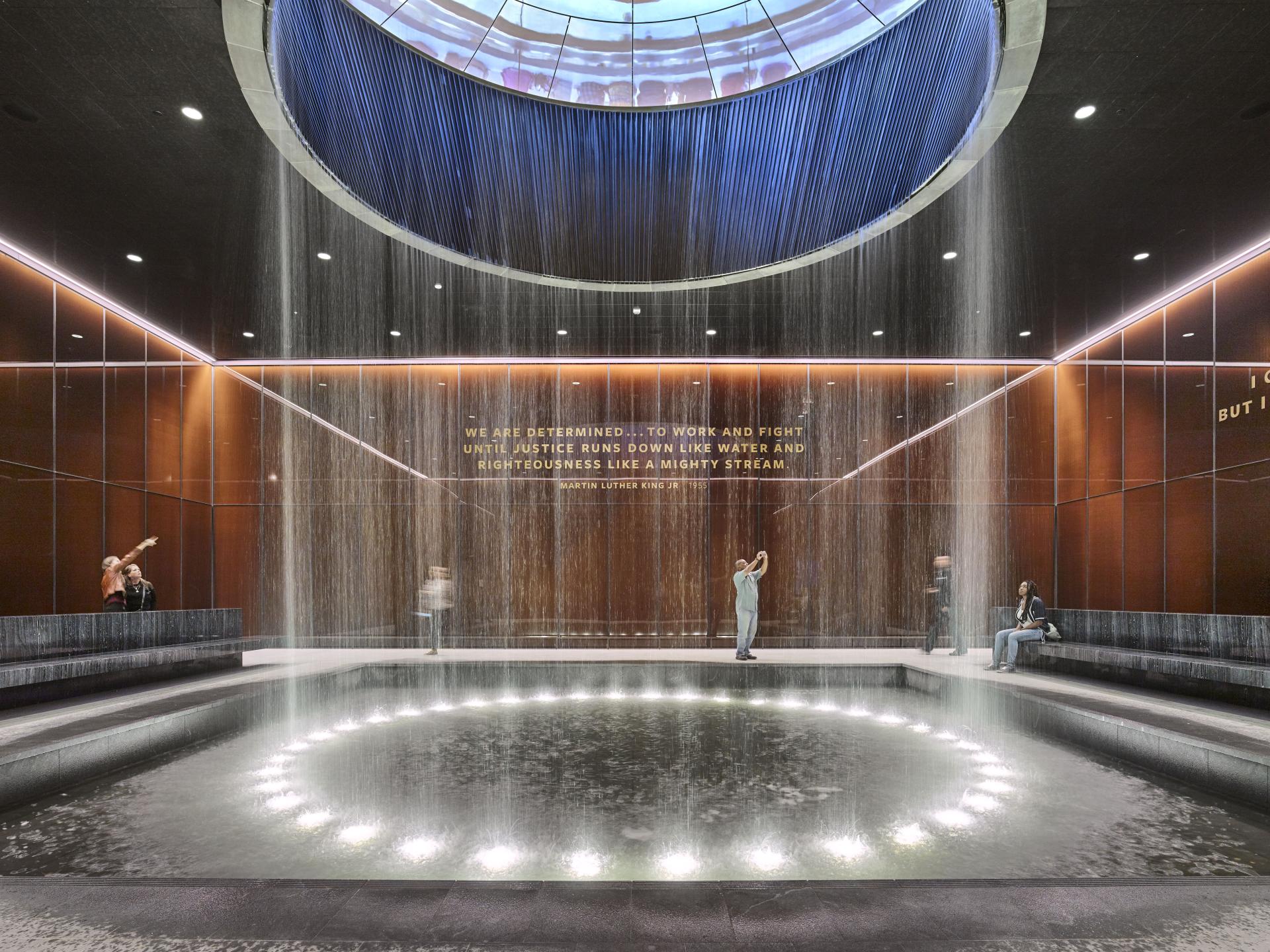 Contemporary memorial design featuring a water installation, reflecting themes of justice and remembrance as part of the exhibition.