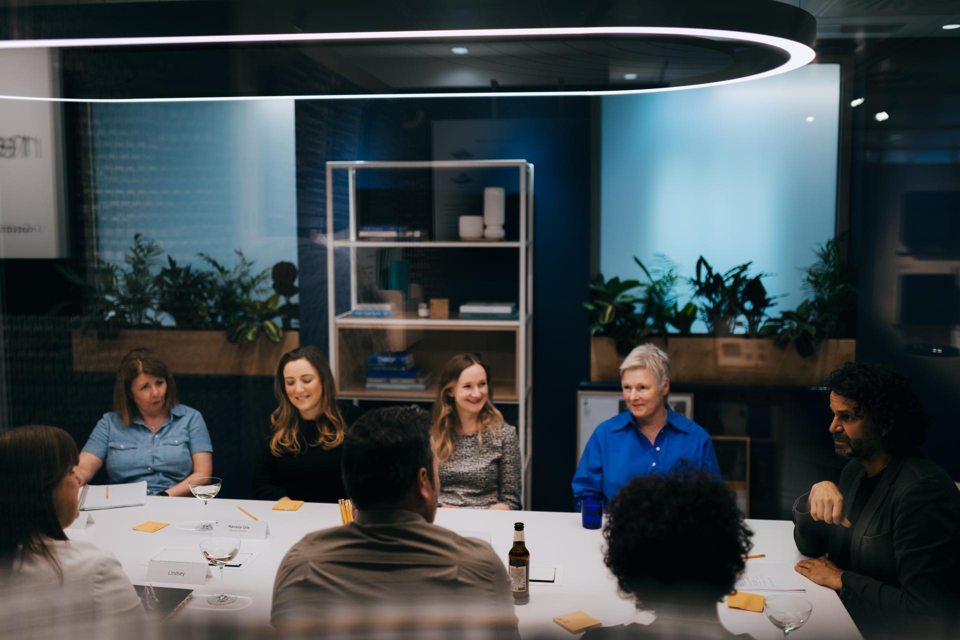 Discussion on neurodiversity at Material Source Studio, featuring diverse participants engaged in conversation around a table.