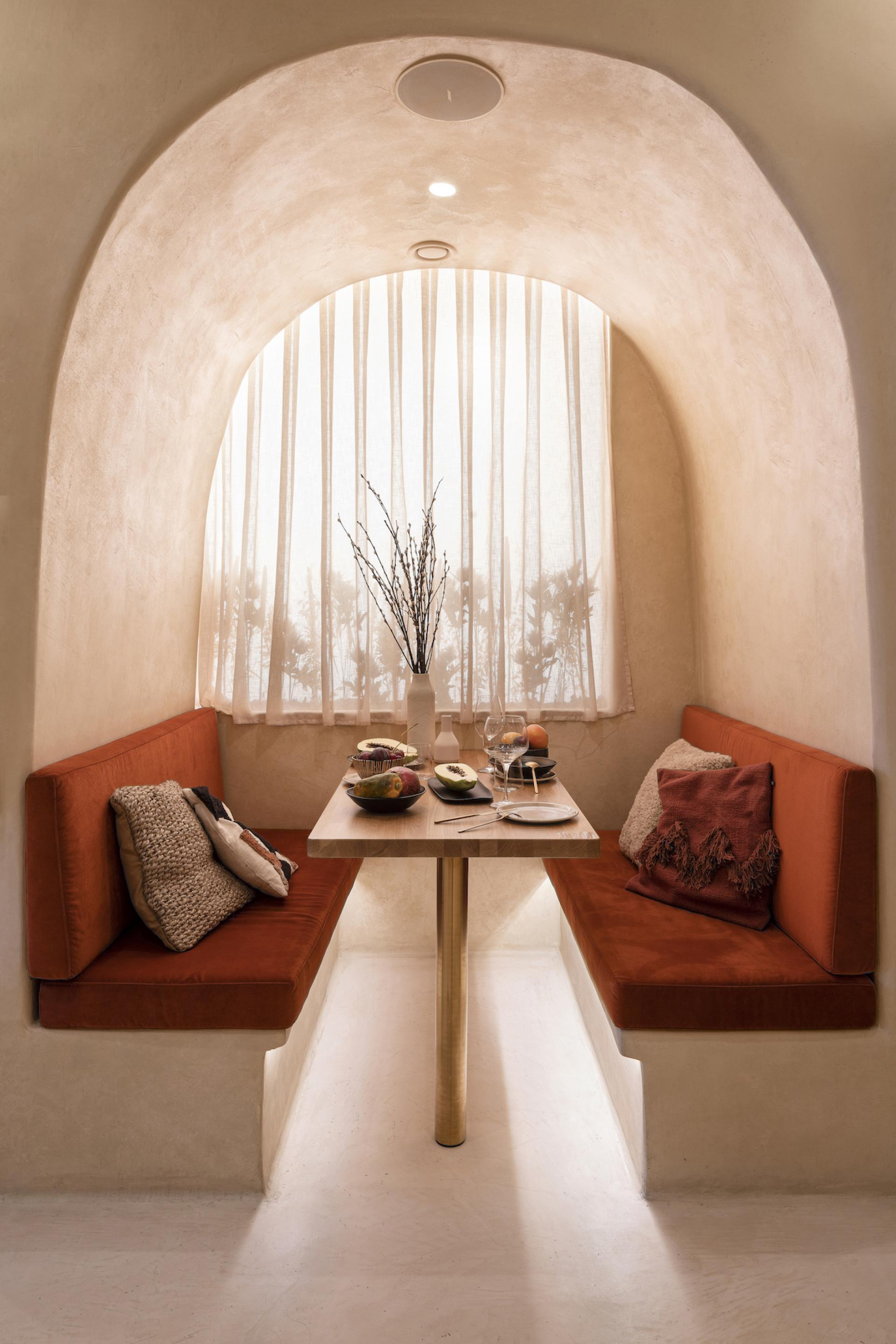 Cozy dining nook in the Living Bakkali restaurant, featuring Middle Eastern-inspired design and fresh fruit on the table.